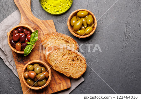 An assortment of various olives presented in a bowl, showcasing different colors, textures, and flavors 122464016