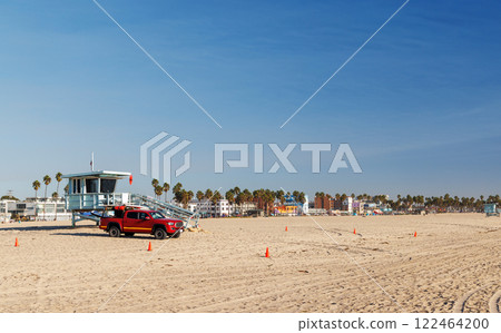 Classic lifeguard tower paired with a rescue vehicle parked nearby on a sandy beach 122464200