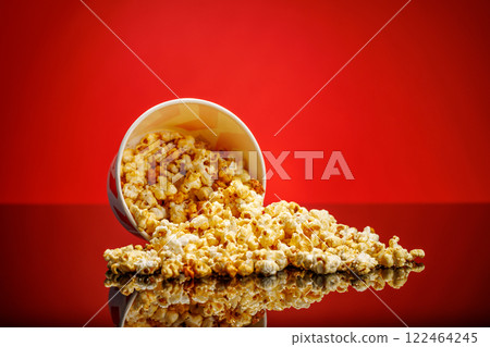 A box of fluffy popcorn against a vibrant red background A box of fluffy popcorn against a vibrant red background 122464245