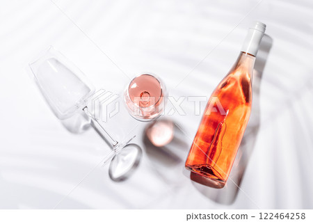 A bottle of rose wine paired with a glass 122464258