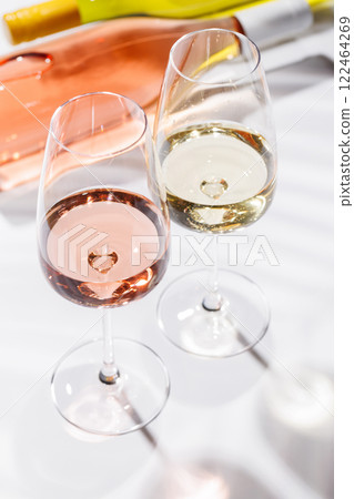 Two wine glasses filled with rose and white wine 122464269