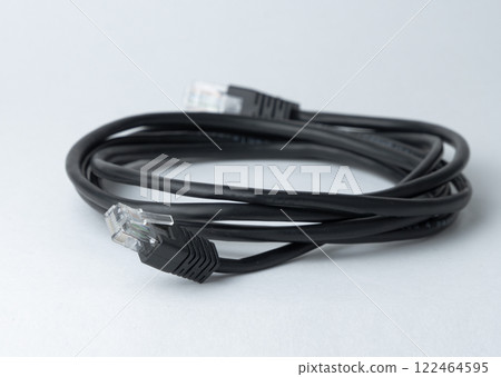 Black ethernet cable lying on a plain surface. High quality photo 122464595