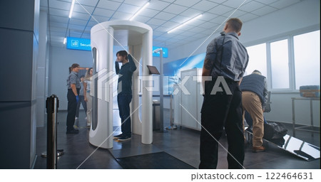 Diverse Passengers Passing Through Metal Detector Scanner, Taking Suitcases from Conveyor Belt Diverse Passengers Passing Through Metal Detector Scanner, Taking Suitcases from Conveyor Belt 122464631