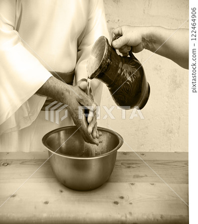 The servant pours water, and the master washes his hands The servant pours water, and the master washes his hands 122464906