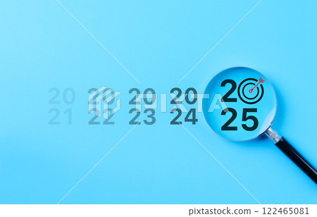 The 2025 New Year business goals concept. Magnifying glass focus year 2025 with a target icon, representing focus on business goals and objectives for the future. Marketing trend, business growth, 122465081