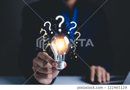 Question mark and problem solving concept. Glowing lightbulb with question marks, symbolizing ideas, problem-solving, and brainstorming. It conveys innovation, curiosity, and search for solutions. Question mark and problem solving concept. Glowing lightbulb with question marks, symbolizing ideas, problem-solving, and brainstorming. It conveys innovation, curiosity, and search for solutions. 122465129