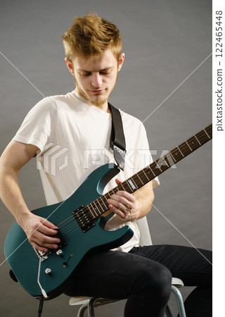 Young man playing electric guitar 122465448