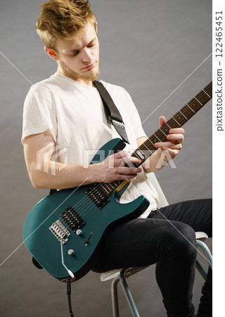Man playing on electric guitar 122465451