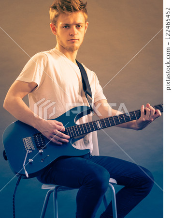 Young man playing electric guitar 122465452