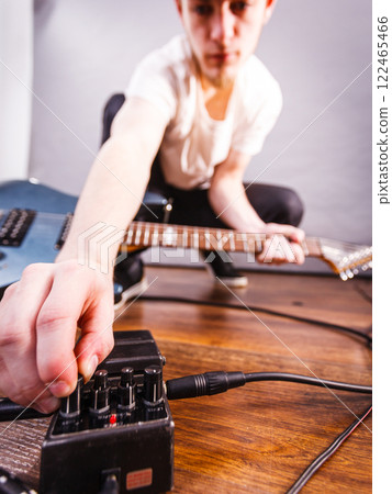 Man setting up guitar equipment Man setting up guitar equipment 122465466