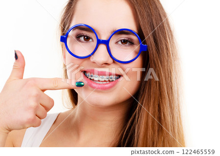Nerdy woman showing her teeth with braces 122465559