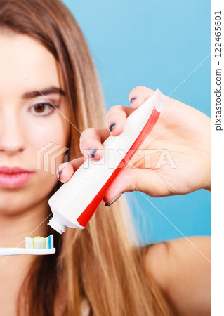 Woman applying toothpaste on her toothbrush Woman applying toothpaste on her toothbrush 122465601