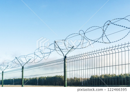 Barbed wire fence on sky background.  122466395