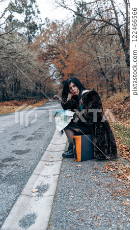 Woman with suitcase on the road Woman with suitcase on the road 122466566