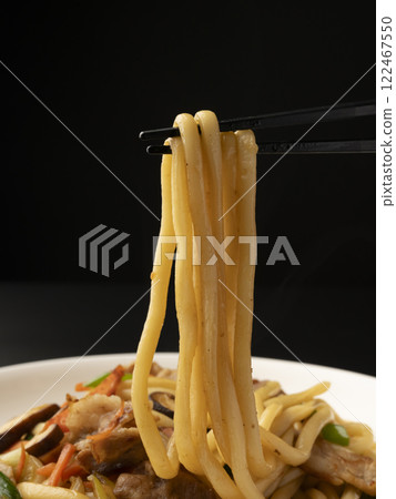 Pick up the fried udon noodles on a plate with chopsticks 122467550