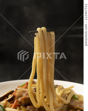 Pick up the fried udon noodles on a plate with chopsticks Pick up the fried udon noodles on a plate with chopsticks 122467552