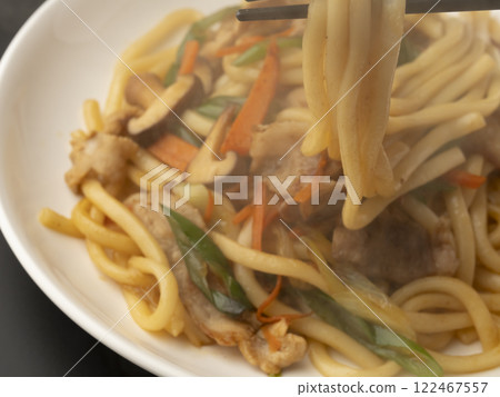 Pick up the fried udon noodles on a plate with chopsticks 122467557