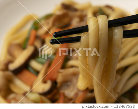 Pick up the fried udon noodles on a plate with chopsticks 122467558