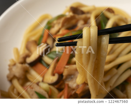 Pick up the fried udon noodles on a plate with chopsticks 122467560