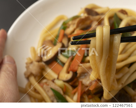 用筷子夾起盤子裡的炒烏龍麵 122467561