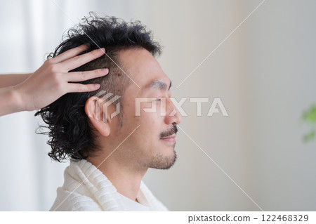 Man receiving a head massage Man receiving a head massage 122468329