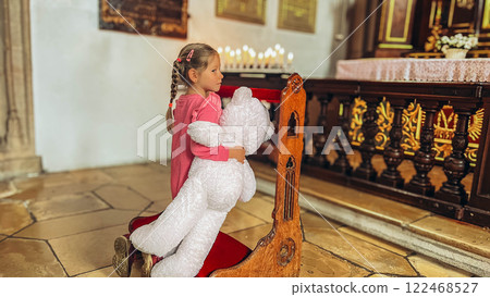 Little girl playing with his toy in catholic church.  122468527