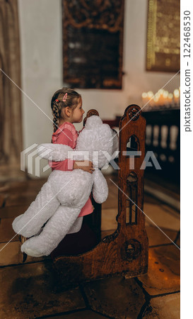 Little girl playing with his toy in catholic church.  122468530