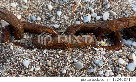 big rusty chain on a pebble beach big rusty chain on a pebble beach 122468714