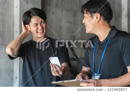 年輕的亞洲男子和私人教練在私人訓練中接受諮詢 122469857