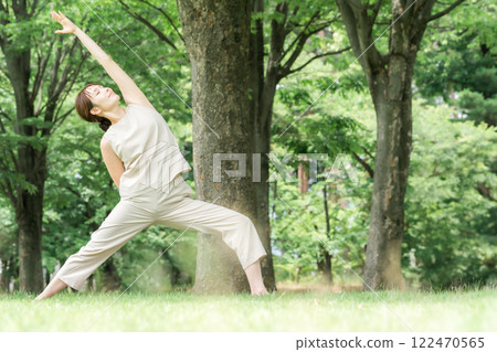 年輕的亞洲女性在公園做瑜珈、瑜珈、皮拉提斯、在森林/公園伸展運動 122470565