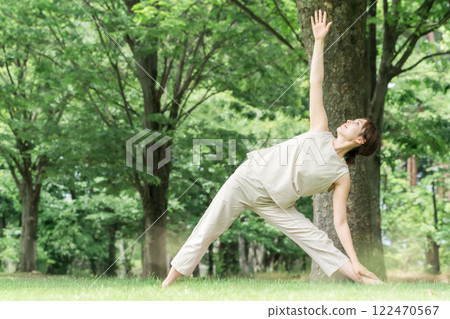 年輕的亞洲女性在公園做瑜珈、瑜珈、皮拉提斯、在森林/公園伸展運動 122470567