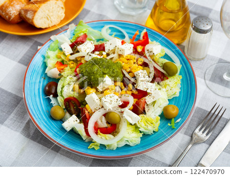 Salad with cheese, pesto sauce, lettuce, tomatoes and olives Salad with cheese, pesto sauce, lettuce, tomatoes and olives 122470970