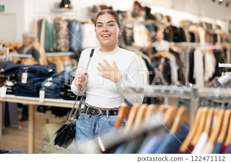 Young woman walking through clothing store Young woman walking through clothing store 122471112