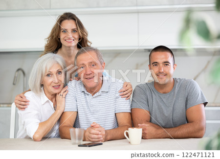 Family of four sitting in kitchen 122471121