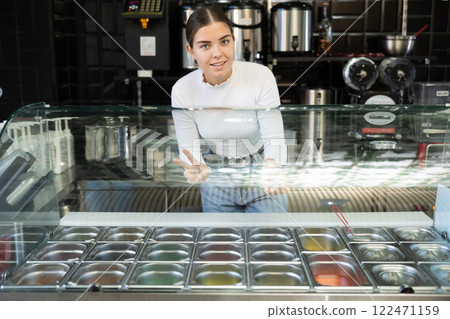 Friendly young saleswoman inviting to try aromatic bubble tea Friendly young saleswoman inviting to try aromatic bubble tea 122471159