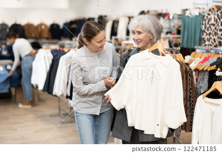 Elderly and adult woman choosing coat in store Elderly and adult woman choosing coat in store 122471185
