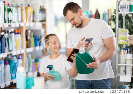 Dad and son scan barcode on packaging of laundry conditioner 122471186