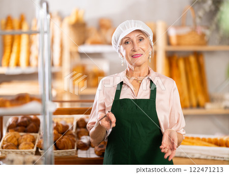Portrait of professional elderly female baker in uniform in bakery 122471213