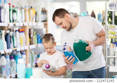 Schoolboy son and dad are choosing big capacity liquid detergent in store Schoolboy son and dad are choosing big capacity liquid detergent in store 122471245