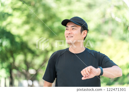 一位身穿運動服的中年男子使用智慧手錶管理自己的健康和保健 一位身穿運動服的中年男子使用智慧手錶管理自己的健康和保健 122471301
