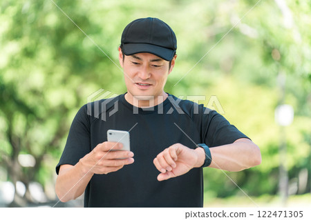 A middle-aged man in sportswear using a smartwatch to manage his health and health care A middle-aged man in sportswear using a smartwatch to manage his health and health care 122471305