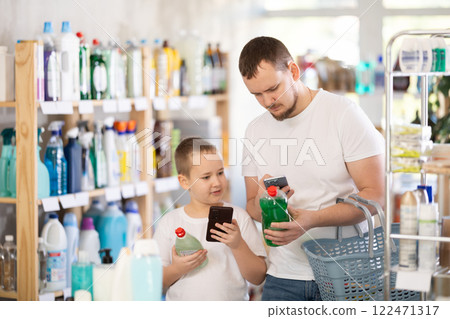 Dad and son scan barcode on packaging of dishwashing Dad and son scan barcode on packaging of dishwashing 122471317