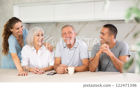 Family of four sits at table and talking 122471396