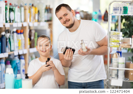 Dad and son client sniffs fragrance of perfume, chooses scent spray with pleasant smell Dad and son client sniffs fragrance of perfume, chooses scent spray with pleasant smell 122471404