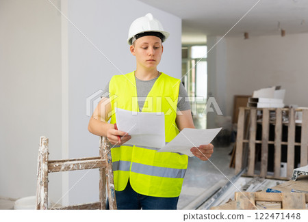 Teenager boy inspecting building site inside apartment 122471448