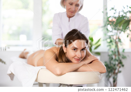 Young woman clinet satisfied with work of masseuse 122471462