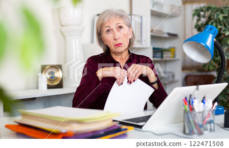 Stressed mature woman working in office 122471508