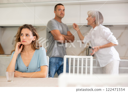 Elderly woman quarrels with couple in kitchen 122471554