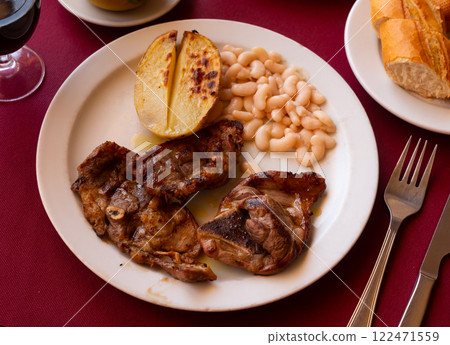Delicious fried lamb ribs with boiled potatoes and beans 122471559