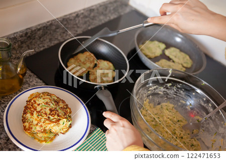 Frying of zucchini fritters Frying of zucchini fritters 122471653